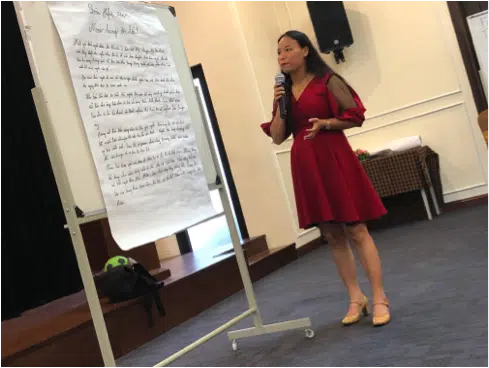 Tackling Trafficking at its Source. 2 image of a lady wearing a red dress giving a speech