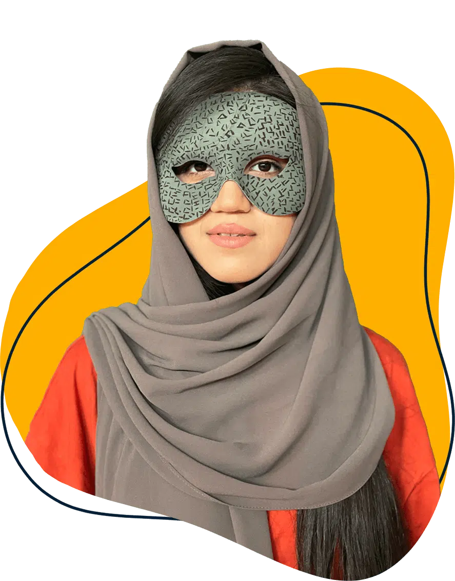 A woman wearing a patterned mask and a grey hijab over a red top stands in front of a white background with a yellow abstract shape behind her.