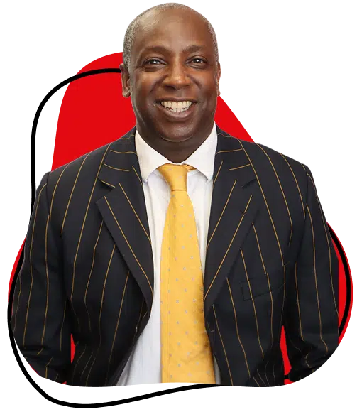 A smiling man in a dark pinstripe suit and yellow tie stands in front of a red abstract background.