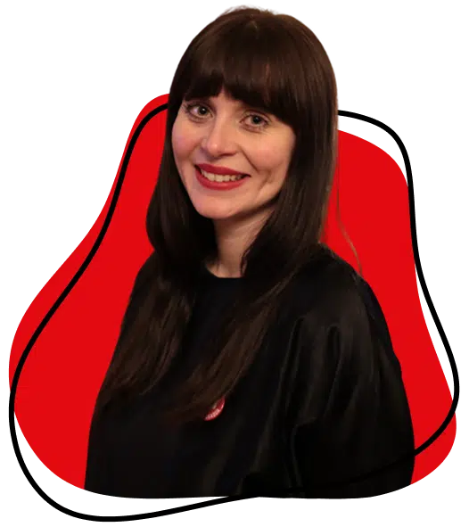 A woman with long dark hair and a fringe smiles at the camera, wearing a black top. The background features an abstract red and white design with black outlines.