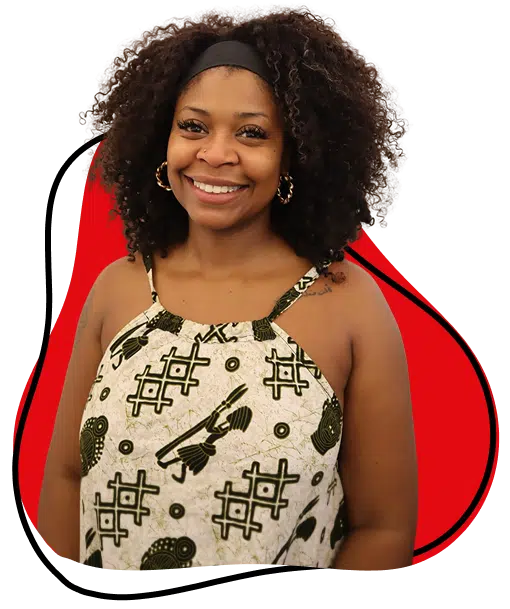 A woman with curly hair wearing a patterned sleeveless top smiles at the camera. She stands in front of a white background with a red and black abstract shape behind her.