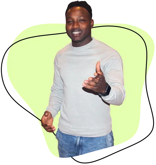 A man wearing a light grey jumper and blue jeans stands smiling, extending one hand forward, against a light green abstract background.