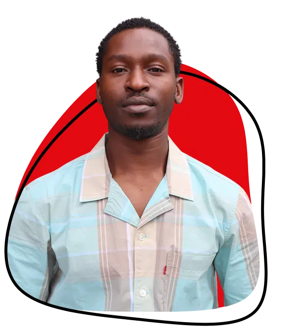A man in a light blue and beige checked shirt stands in front of a white background with a bold red abstract shape and black outline behind him. He looks directly at the camera with a neutral expression.
