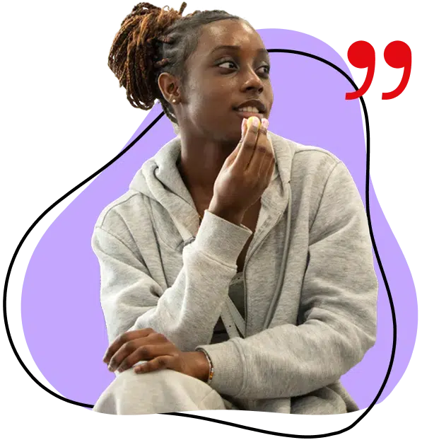 A person with plaited hair wearing a grey hoodie sits with one hand near their chin, looking to the side. A red quotation mark and a purple abstract shape are in the background.