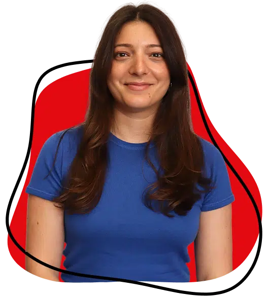 A woman with long brown hair wearing a blue short-sleeved shirt smiles at the camera. Behind her is an abstract red shape outlined in black on a light background.