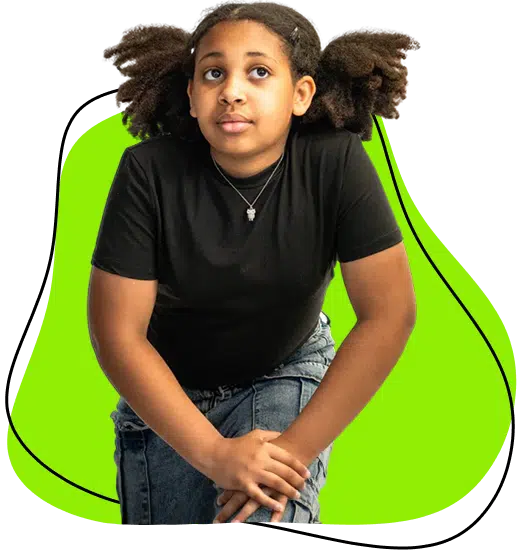 A young girl with curly hair in plaits, wearing a black t-shirt and jeans, kneels while looking upwards. The background features a bright green abstract shape.