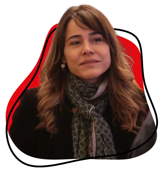 A woman with wavy brown hair and a patterned scarf smiles softly. She is wearing a dark jacket, with a red and black abstract shape in the background.