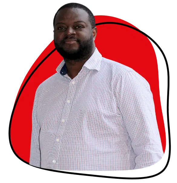 A man with a beard wearing a light-coloured, checked button-up shirt stands in front of a red abstract shape with a black outline on a light background.