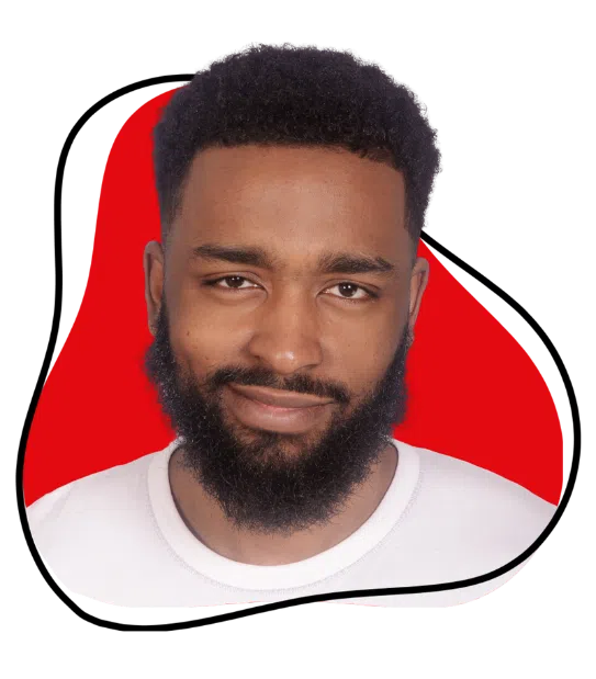 A bearded man in a white t-shirt stands in front of a white background with a bold red abstract shape and black outline behind him. He looks directly at the camera with a smile.